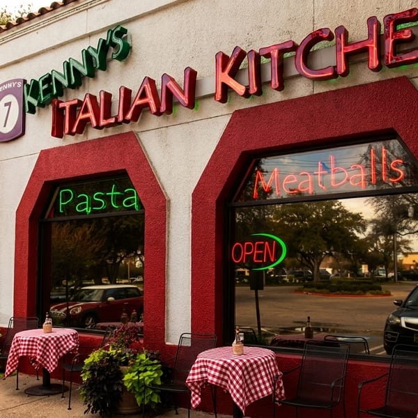 Kenny's Italian Kitchen exterior with neon signs, red and white checkered outdoor tables, and flags.